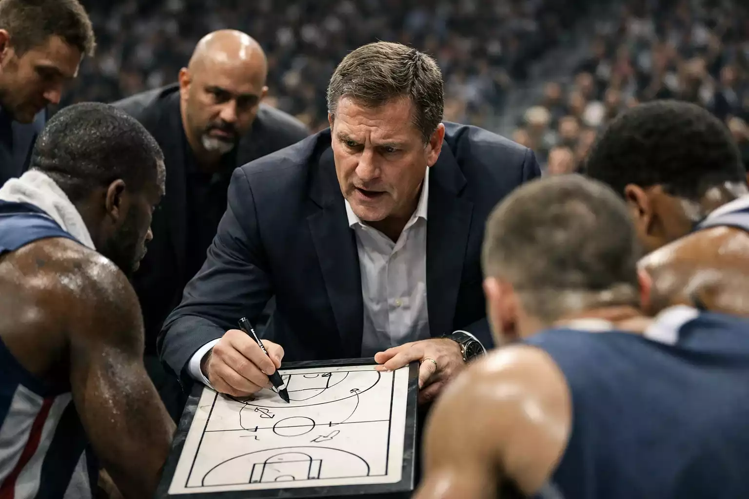 NBA-Trainer bespricht Taktik mit Spielern während einer Auszeit