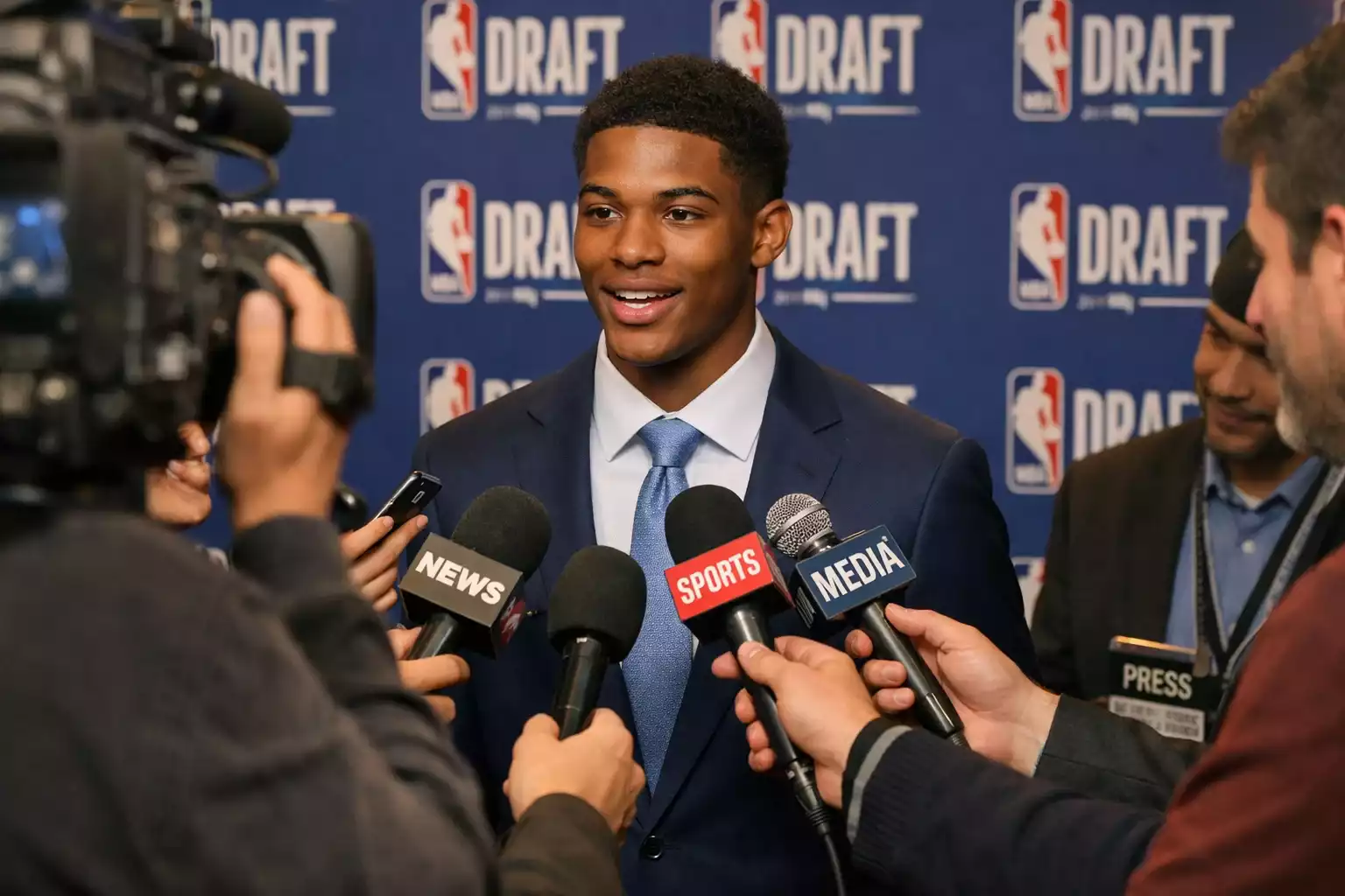 Junger Basketballspieler im Anzug bei Draft-Interview mit Medien